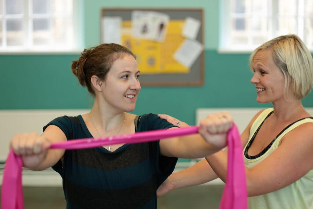 Charlotte with client with pink exercise band.