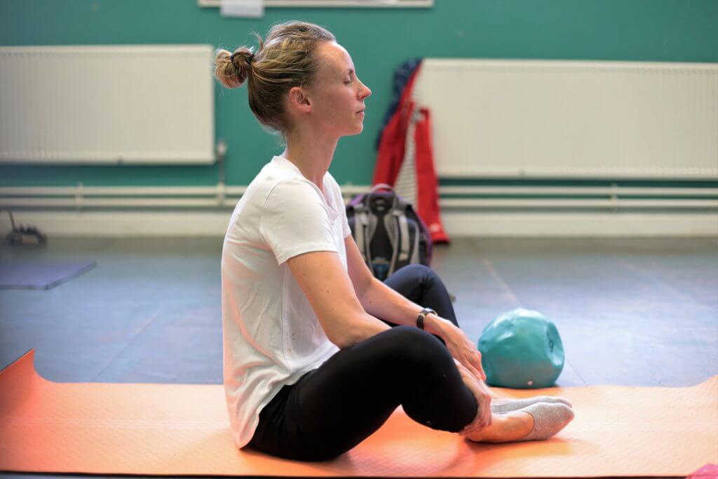 Crossed legged pilates position with eyes closed.