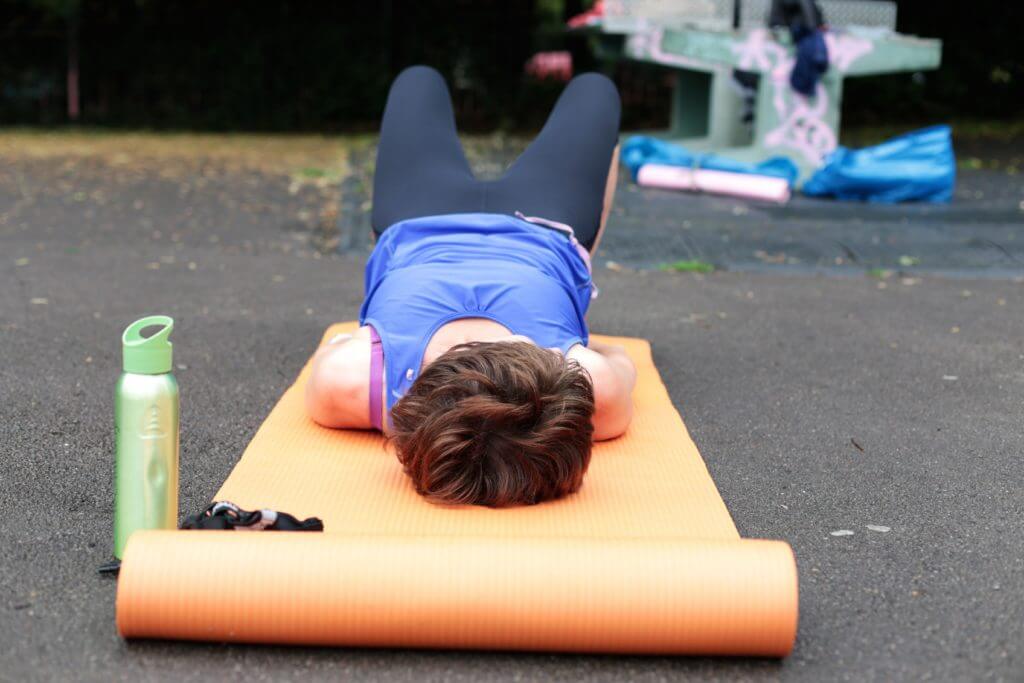 Lady exercising on an orange exercise mat.