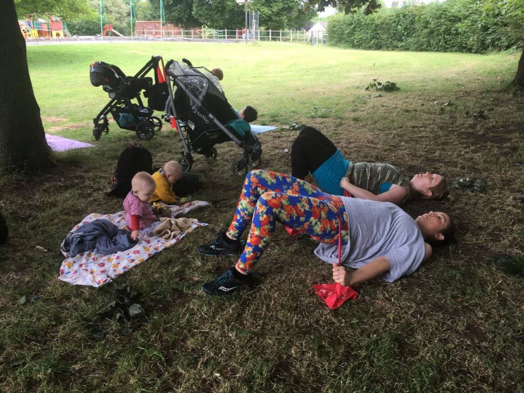 Exercising with babies under a tree.