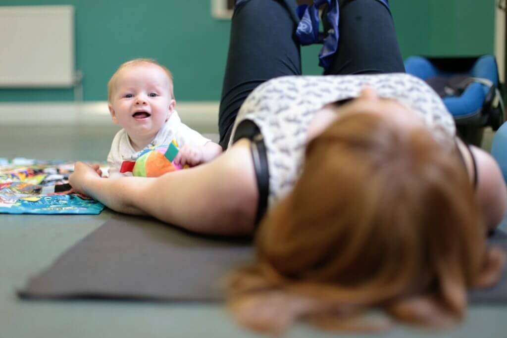 baby and mum lying down at a pilates class.